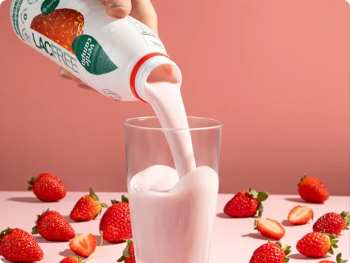 Iogurte de morango Verde Campo servido em um copo ao lado de frutas