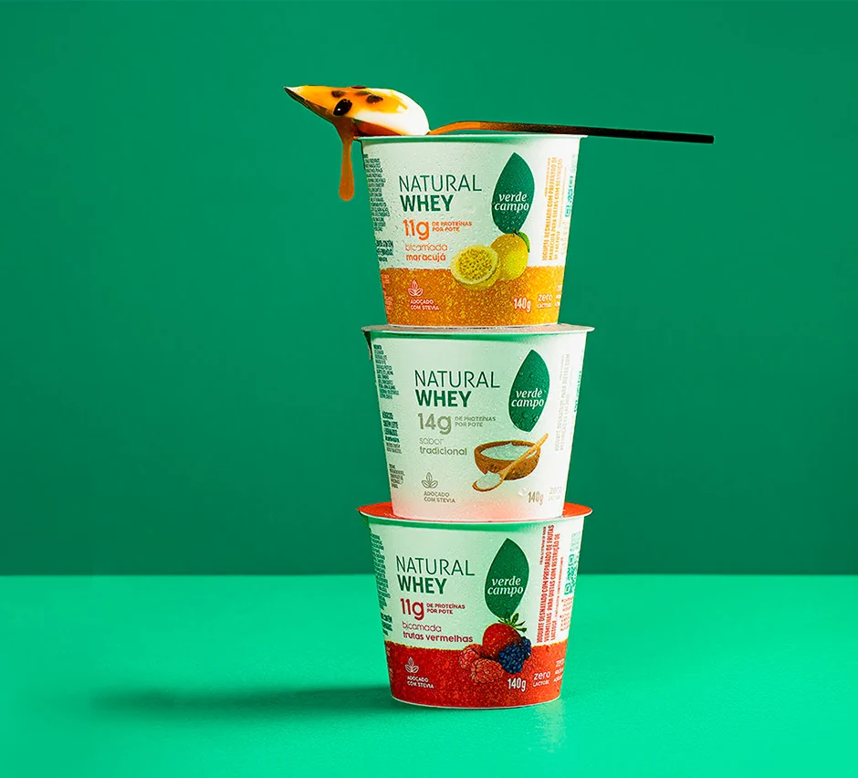 Três potes de iogurte Natural Whey Verde Campo sobre fundo verde